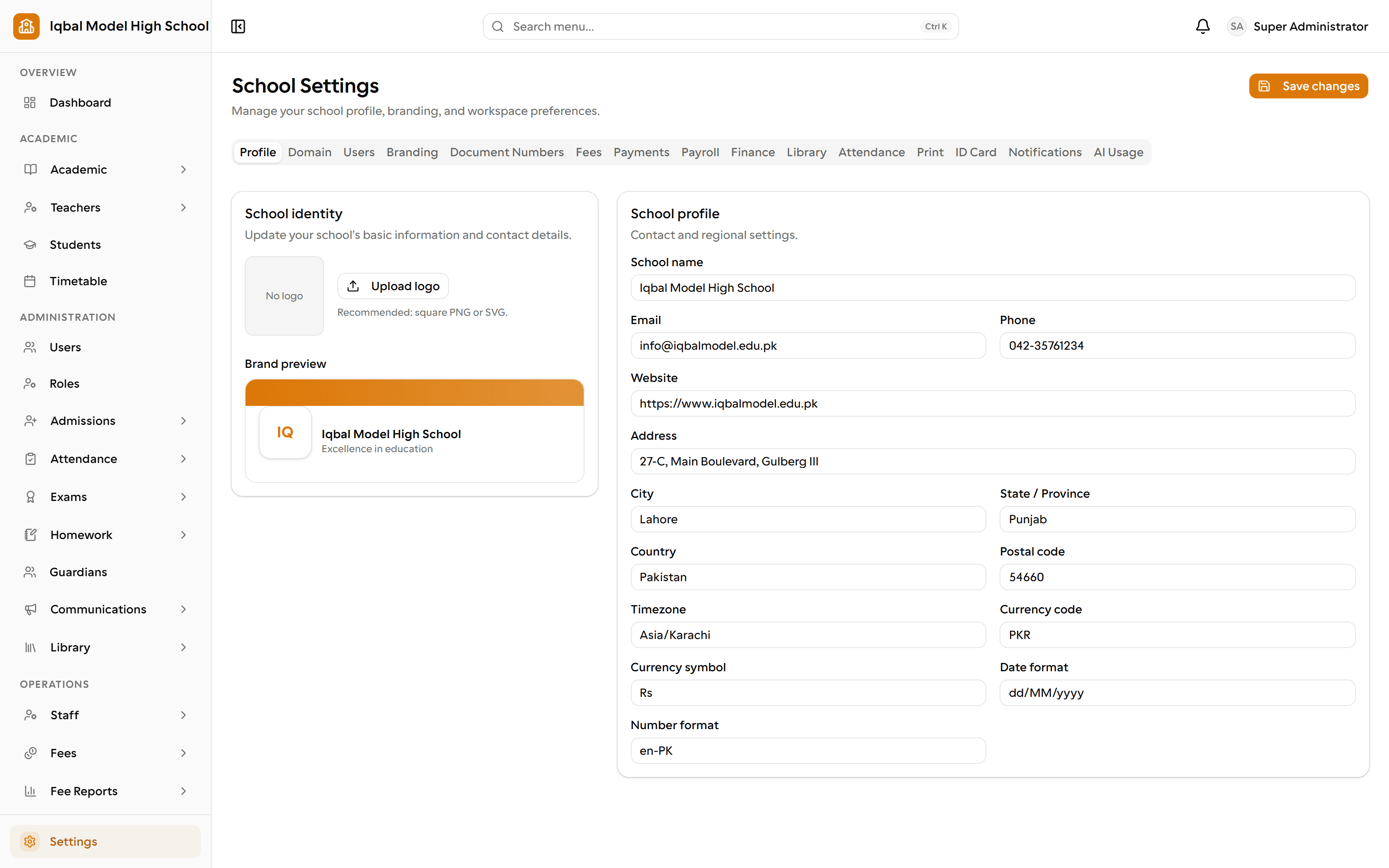 The EDUTIG school settings screen. A logo upload and brand preview sit beside the school profile form with timezone, currency and date format fields, under tabs for domain, users, branding, document numbers, fees, payments, payroll, finance, library, attendance, print, ID card and notifications.
